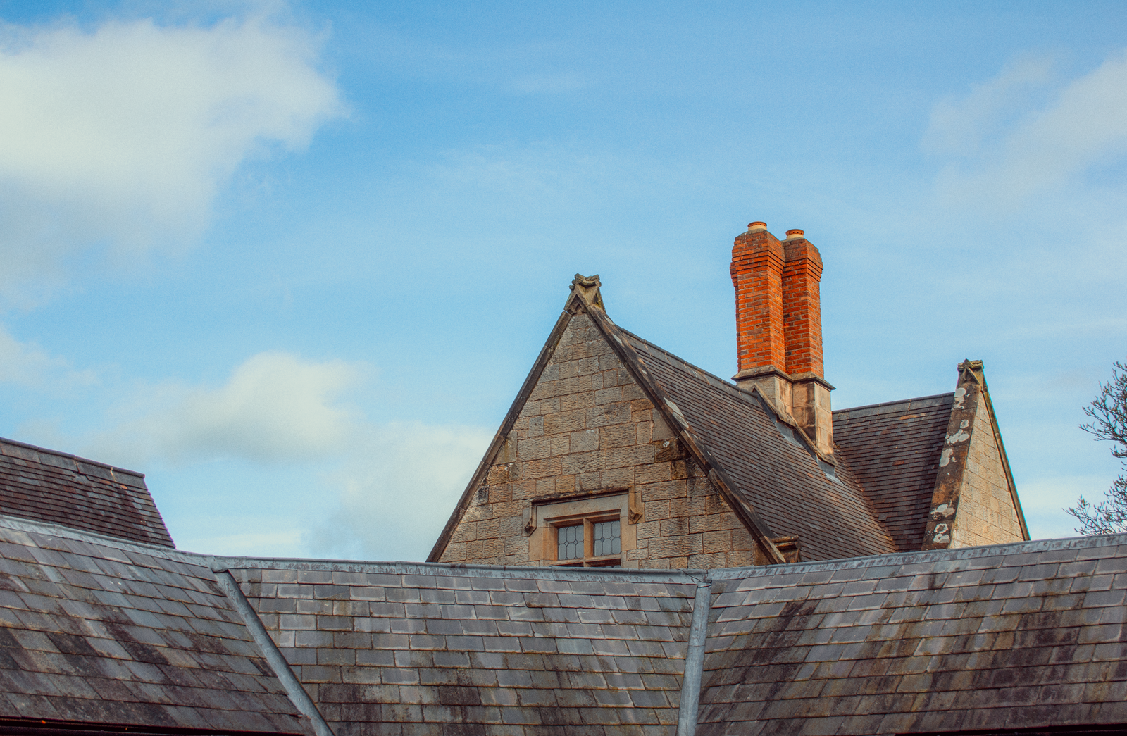 Slate roof and brick chimneys on a stone home